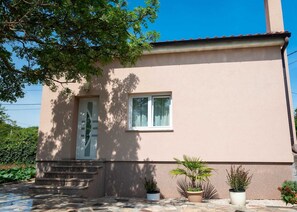 A two-story building with a beige exterior, a front door, a window, and a set of stone steps leading to the entrance. - Holiday house Lucy with private pool (Žgaljići (Krk))