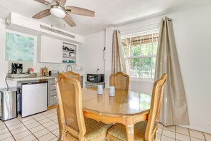 A compact kitchen with a dining area, a ceiling fan, a refrigerator, a microwave, and a coffee maker. - Shared Dock & Fire Pit: Withlacoochee River Gem! (Inglis)