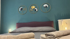 A bedroom with a bed, pillows, and a wall-mounted decoration. - Elegant Apartment Near Metro Line B - Luiss Guido Carli (Roma)