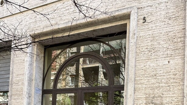 A building entrance with a glass door, a staircase leading inside, and a mailbox on the wall. - Elegant Apartment Near Metro Line B - Luiss Guido Carli (Roma)