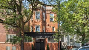 A multi-story brick building with a black entrance door, windows, and a visible address number. - The Lincoln Square Hideaway (Chicago)