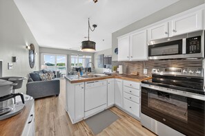 A modern kitchen with white cabinetry, a built-in oven, and a microwave. - #233 Pointe - 2 Bedroom Lakefront Condo at Mariners SML (Bedford County)