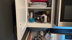 A kitchen with a microwave, stove, and various kitchen utensils and appliances.
