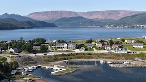 A lakeside community with houses, a marina, and mountains in the background.
