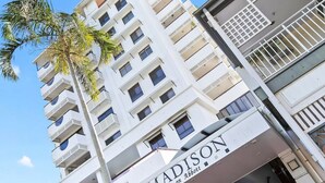 Un hôtel à plusieurs étages, doté de balcons et d’une enseigne indiquant « Madison on Abbott ».