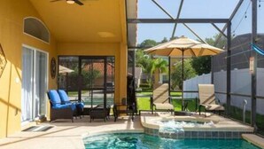Un área de piscina con jacuzzi, sillones de descanso y sombrillas.