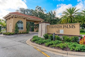 A sign for Veranda Palms with a clear view of the entrance and surrounding landscaping. - 4BR Pool & Spa Home Near Disney (Kissimmee)