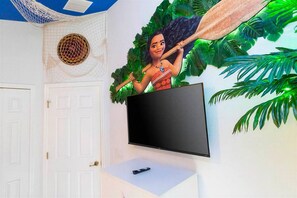A room with a mounted television on a white wall, a door with a brass handle, and a ceiling with a blue and white pattern. - 4BR Pool & Spa Home Near Disney (Kissimmee)