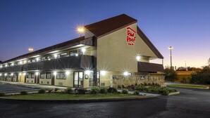 Un Red Roof Inn con diseño moderno, que cuenta con un amplio estacionamiento e iluminación exterior.