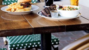 A dining table with a burger, fries, a salad, and two glasses of beer. - Mortdale Hotel (Mortdale)