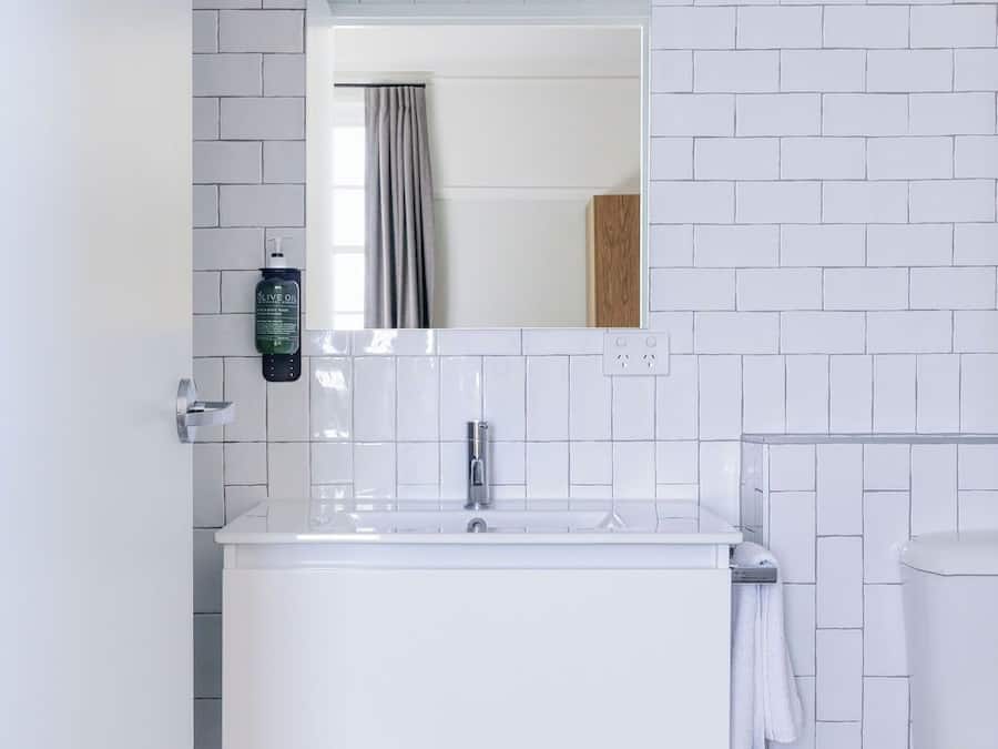 Un baño con lavamanos blanco, un espejo y un inodoro.
