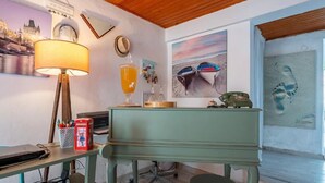 A room with a desk, a lamp, a chair, and artwork on the walls.