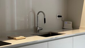 Eine moderne Küche mit einem Edelstahlarmaturen, einer integrierten Spüle und einer Arbeitsplatte.