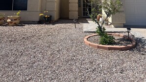 A house with a tiled roof, a garage, and a gravel driveway. - Enjoy an oasis's over looking the golf course  (Fort Mohave)