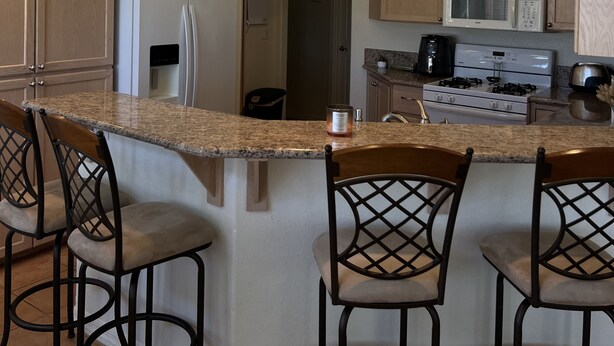 A modern kitchen with a central island, bar stools, and built-in appliances. - Enjoy an oasis's over looking the golf course  (Fort Mohave)