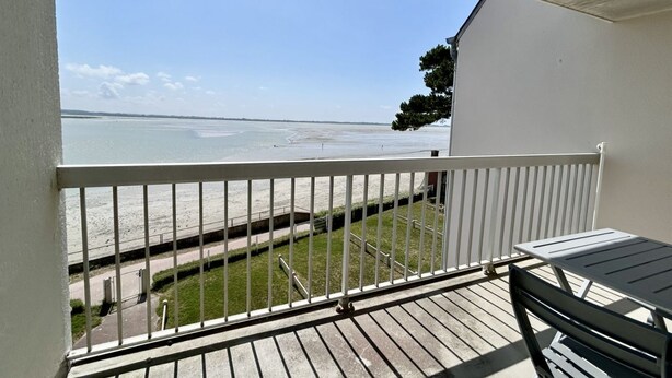 A balcony with a view of the beach, a white railing, and a table. - Les chouettes, apartment for 4 people (Le Crotoy)