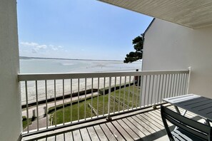 A balcony with a view of the beach, a white railing, and a table. - Les chouettes, apartment for 4 people (Le Crotoy)