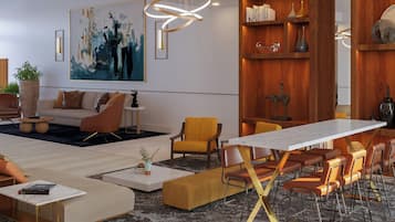 Ein modernes Wohnzimmer mit einer Couch, Sesseln, einem Couchtisch und einem Essbereich mit Tisch und Stühlen.