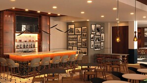 Uma área de bar moderna com balcão, assentos e quadros nas paredes.
