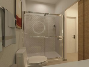 Ein Badezimmer mit Toilette, Duschkabine und Spiegel.