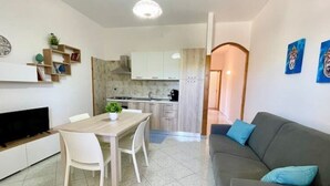 Un espace de vie compact comprenant un coin repas, une kitchenette et un canapé.
