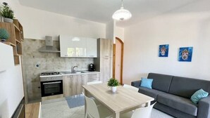 Un espace de vie compact comprenant une kitchenette, un coin repas et un canapé.