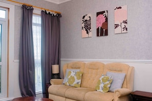 Family Apartment, Multiple Beds | Living area | 38-inch flat-screen TV with digital channels