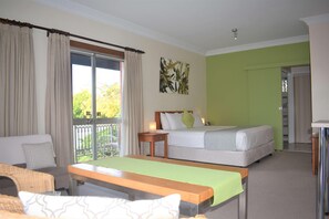Ein Hotelzimmer mit Bett, einer Couch, einem Tisch und Blick ins Freie.