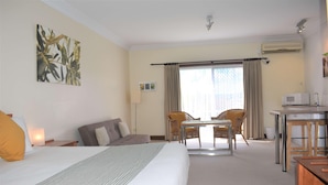A hotel room with a bed, a desk, a chair, a lamp, and a window with curtains. - The Henry Parkes Tenterfield Ex Best Western (Tenterfield)