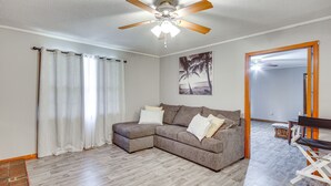 A living room with a sectional sofa, a ceiling fan, and a wooden floor. - Quiet & Cozy Rembert Home ~ 9 Mi to Air Force Base (Rembert)