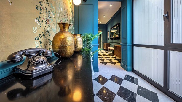 A lobby with a vintage rotary phone, large brass vases, and a checkered floor. - Hs4U Ricasoli Luxury apartment near Duomo N. 3 (Firenze)