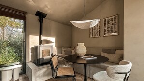 Una sala de estar moderna con una estufa de leña, una mesa redonda y dos sillas.
