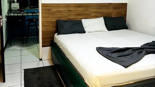 Une chambre à coucher comprenant un lit, un bureau et une chaise, le tout situé dans la pièce adjacente.