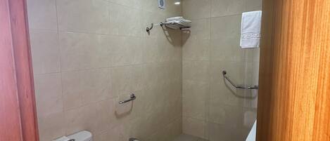 A bathroom with a toilet, bidet, and a small sink.
