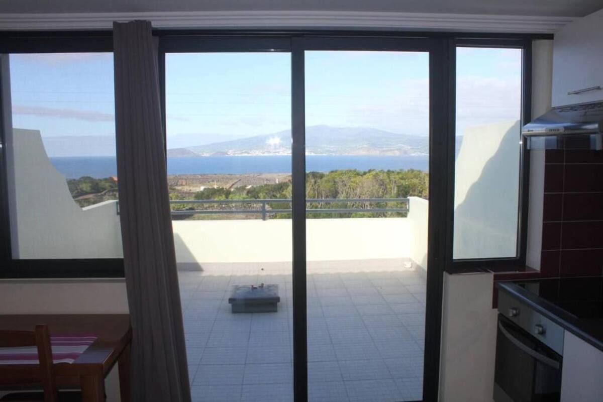 A balcony with a view of the sea and mountains.