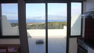Un balcón con vista al mar y a las montañas.