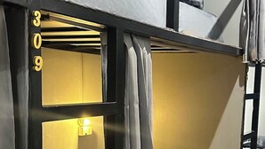 A bunk bed room with a window, a bedside lamp, and a curtain. - Bed Space Hostel  (Bangkok)