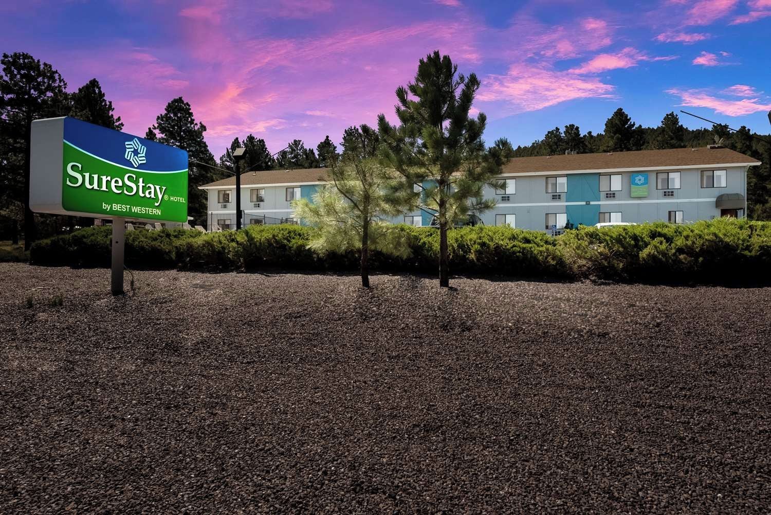 A SureStay hotel sign with a building in the background.