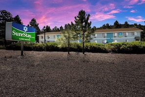 A SureStay hotel sign with a building in the background. - Surestay by Best Western Williams - Grand Canyon (Williams)