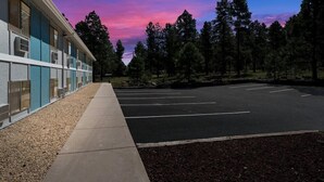 A building with a parking lot and trees in the background. - Surestay by Best Western Williams - Grand Canyon (Williams)