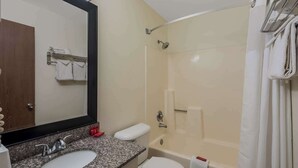 Un baño con lavamanos, espejo, inodoro y bañera.