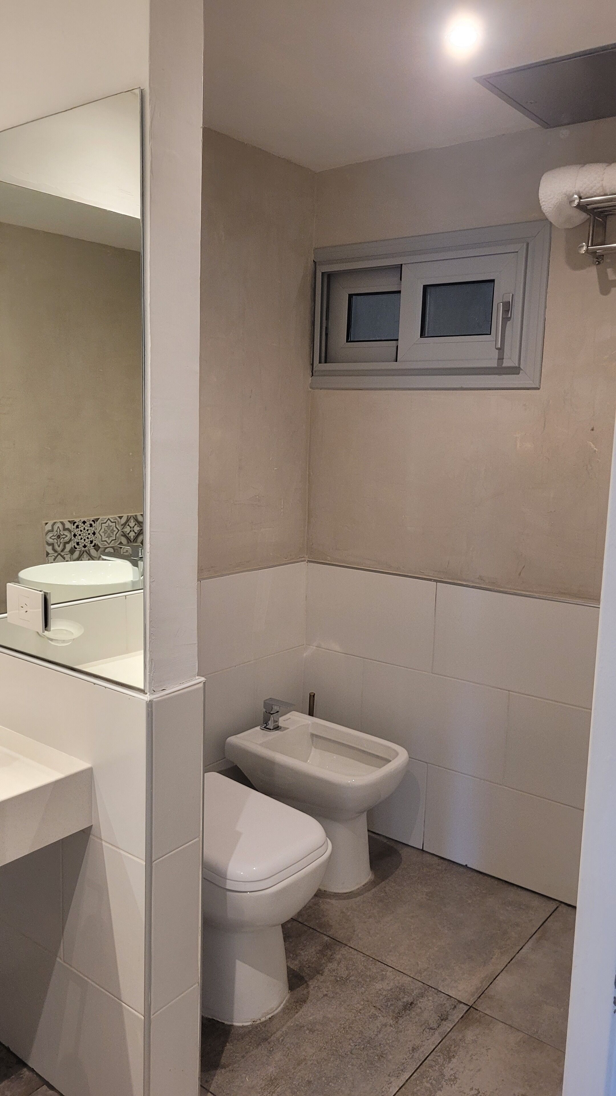Ein Badezimmer mit Toilette, Bidet und Spiegel.