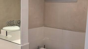 Ein Badezimmer mit Toilette, Bidet und Spiegel.