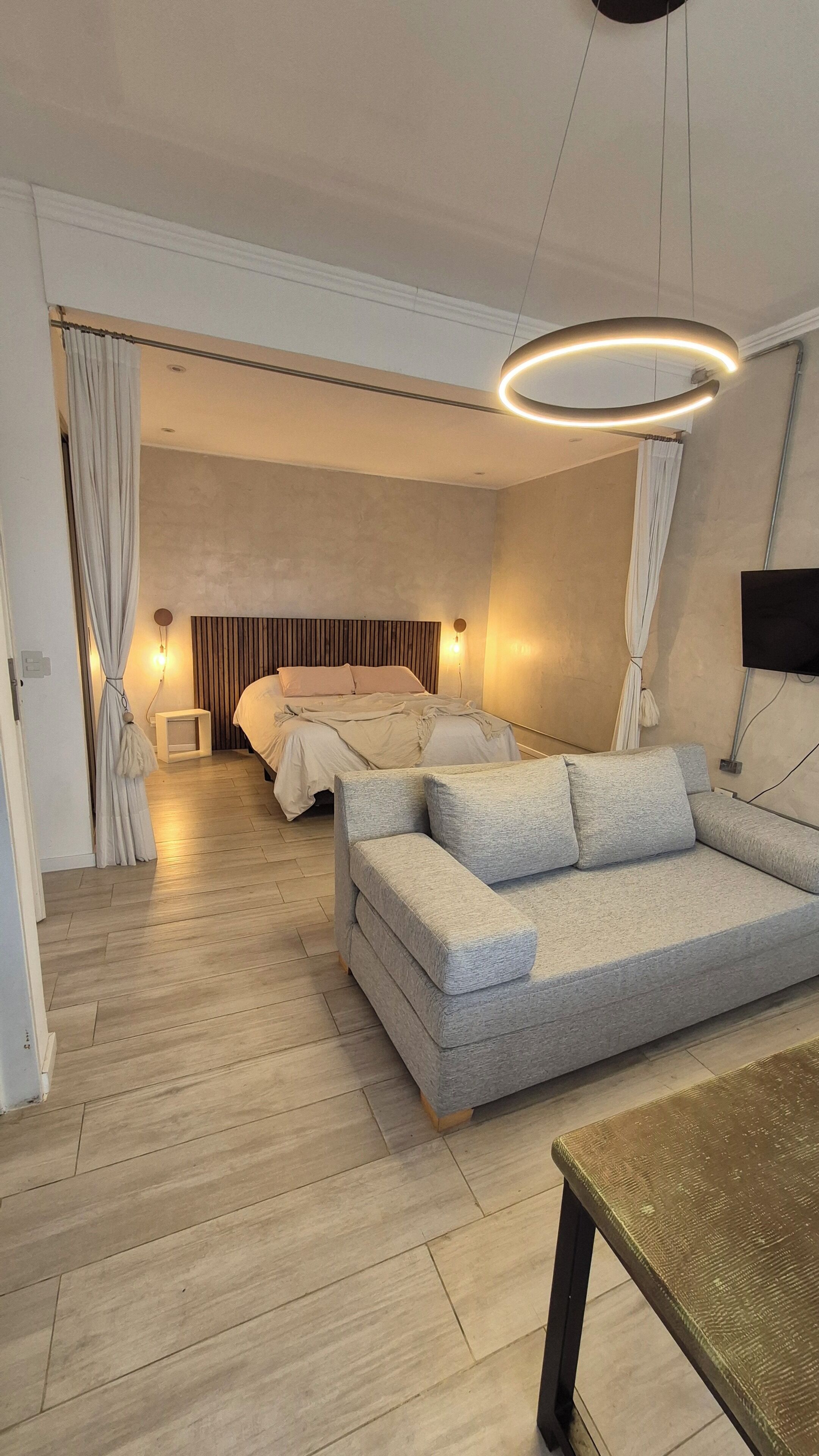 Un dormitorio moderno con una cama, un sofá y una televisión.