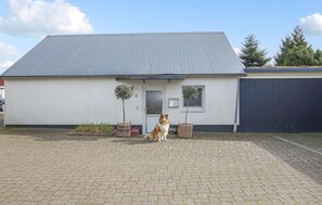 Guests can park their vehicles in the driveway, surrounded by potted plants and trees.