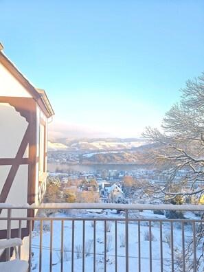 Enjoy breathtaking views of the snow-covered river, town, and distant hills from this balcony.