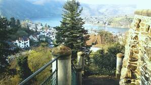Una scala conduce a un punto panoramico con vista su una città, un corpo d'acqua e colline all'orizzonte.