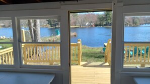 A wooden deck with a view of a lake and surrounding trees.