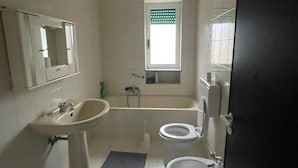 Une salle de bain avec un lavabo, des toilettes et une baignoire.