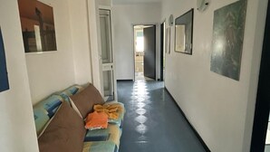 Un couloir avec un canapé, une porte et un autre couloir menant à une autre pièce.